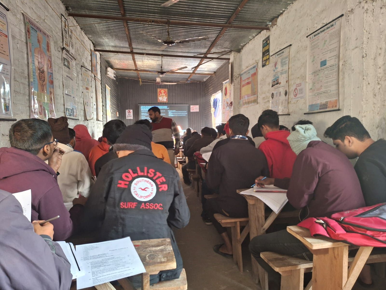 Students solving printed weekly assessment mock test papers at Pragyan Institute
